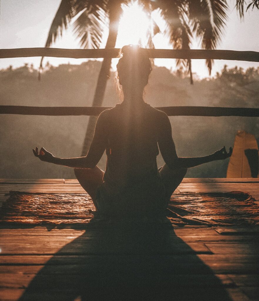 Person meditating peacefully in morning light in nature